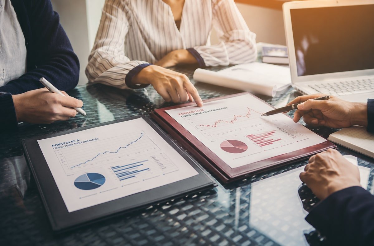 Financial advisors reviewing investment portfolio performance and estate planning strategies.